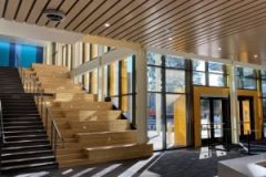 Beautifully Constructed Building Entryway With Wood Stairs And Glass Doors.